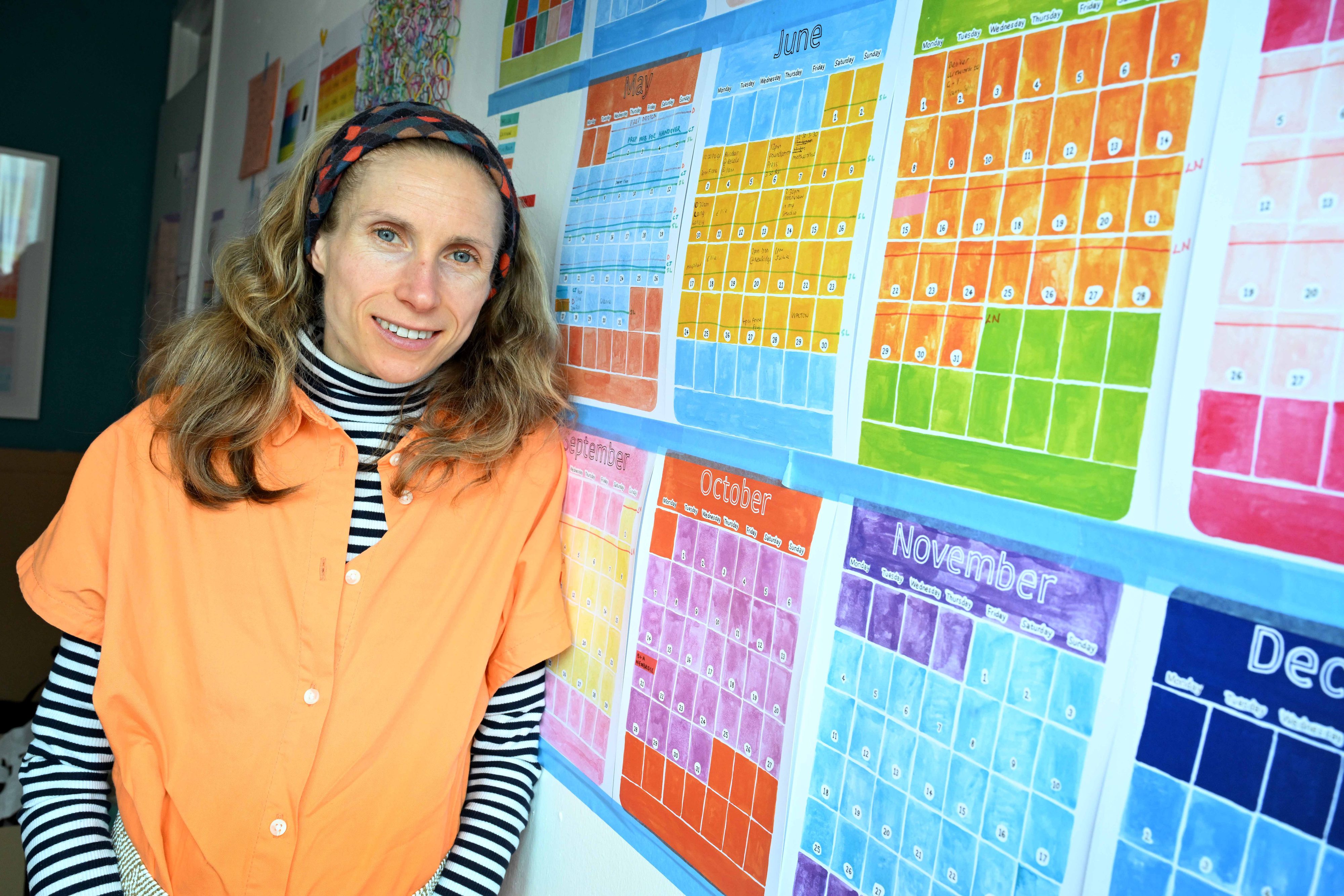 Helen posing with a calendar in her workshop