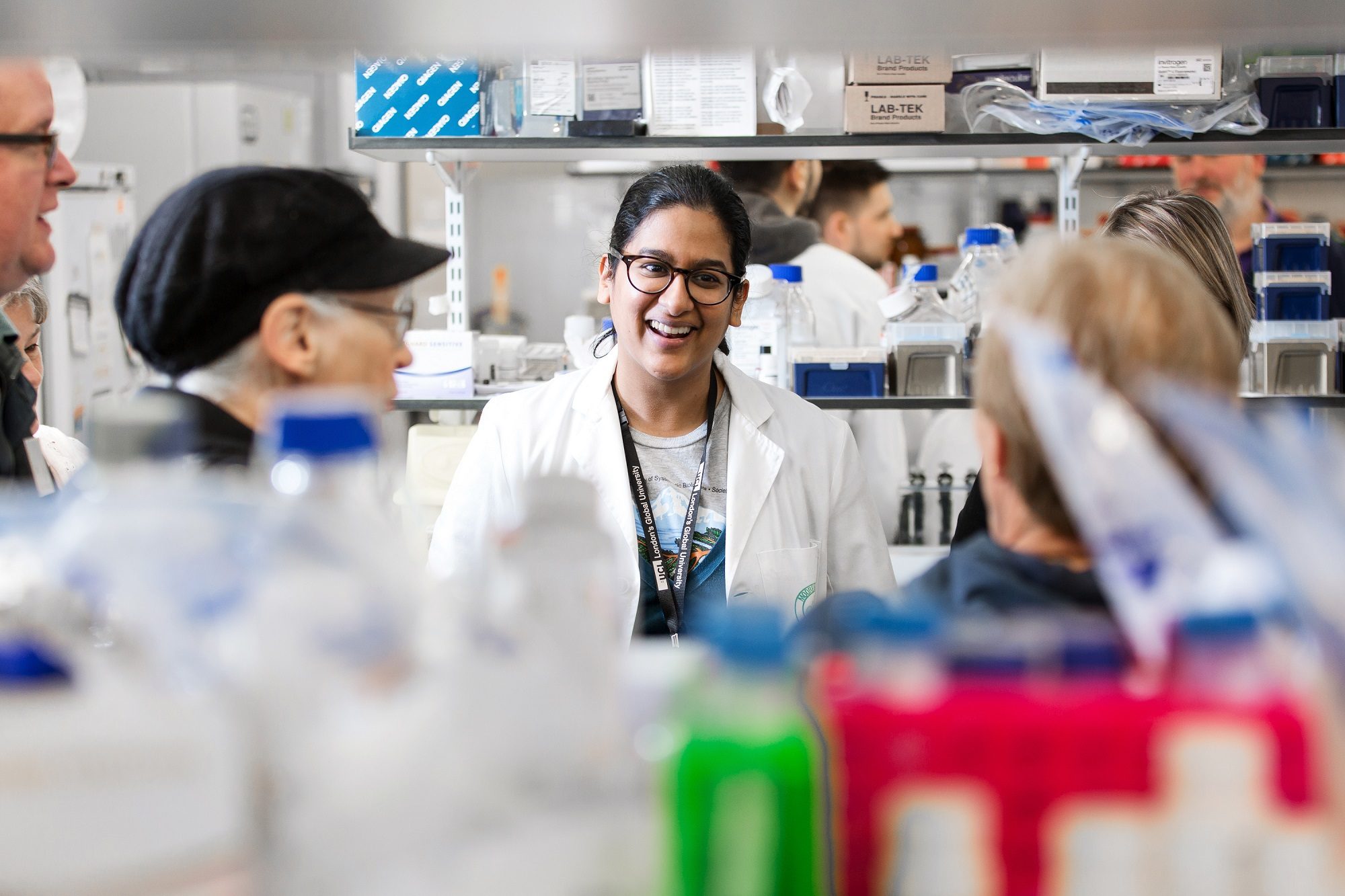 Female eye health researcher in laboratory smiling for Moorfields Eye Charity partnership